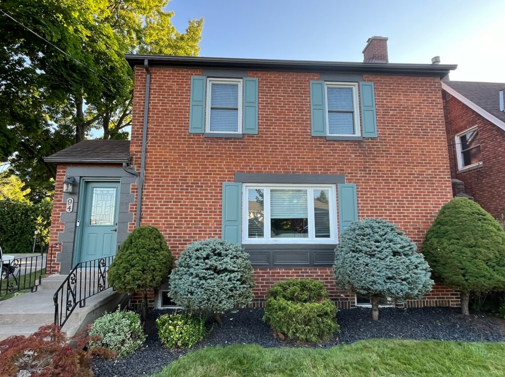 brick house with painted gutters and windows